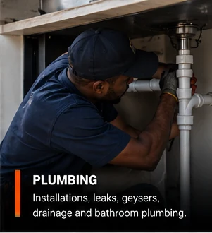 Plumber tightening pipework beneath a sink